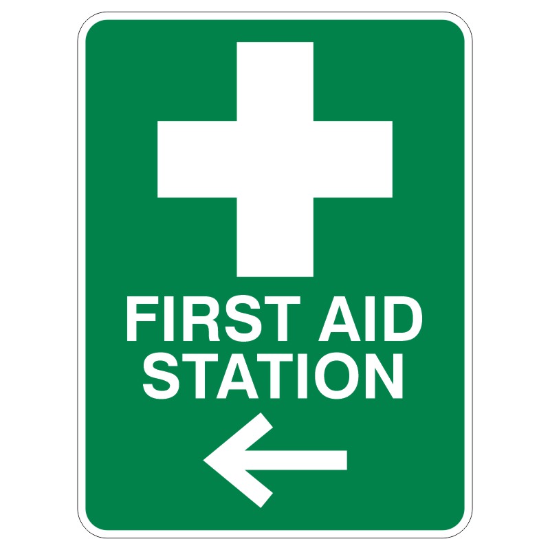 A green sign displaying a white cross symbol and the text FIRST AID STATION with a left-pointing arrow.