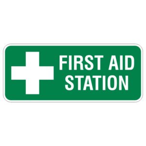 A green sign displaying a white cross symbol and the text FIRST AID STATION in bold white letters.