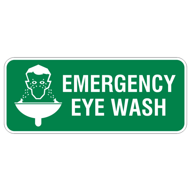 A green sign with white text reading EMERGENCY EYE WASH accompanied by an icon of a person's head under a hose, indicating the use of an eye wash station.