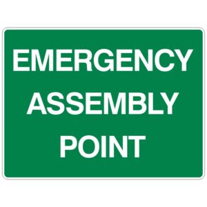 A green sign with white text reading EMERGENCY ASSEMBLY POINT.