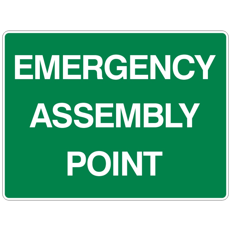 A green sign with white text reading EMERGENCY ASSEMBLY POINT.