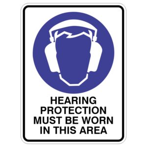 A safety sign featuring a head silhouette wearing earmuffs against a blue background, with the text stating HEARING PROTECTION MUST BE WORN IN THIS AREA below it.