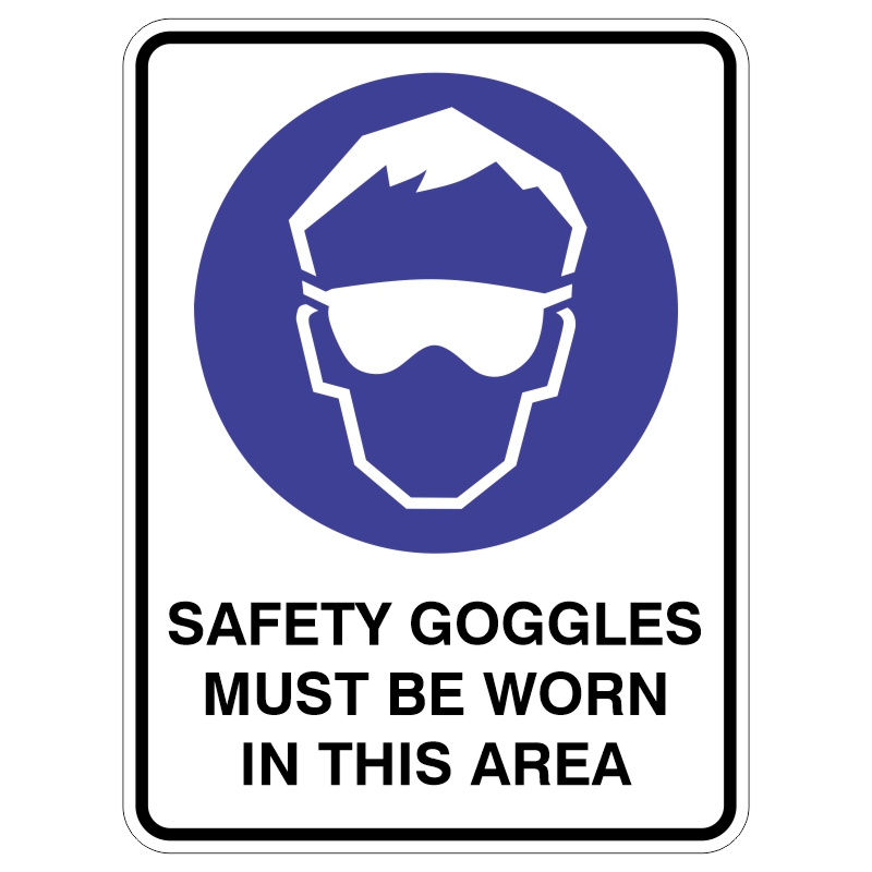 A safety sign featuring a blue circular icon of a person wearing goggles, with the text SAFETY GOGGLES MUST BE WORN IN THIS AREA below.