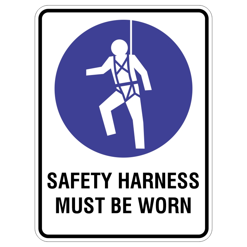 A safety instruction sign featuring a white figure wearing a safety harness, suspended from above, set against a blue circle, with the text SAFETY HARNESS MUST BE WORN in bold black letters at the bottom.