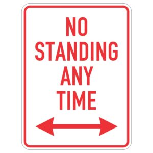 A white sign with bold red text stating NO STANDING ANY TIME flanked by two red arrows pointing left and right.