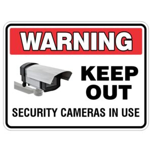 A warning sign indicating 'KEEP OUT' with a graphic of a security camera and the text 'SECURITY CAMERAS IN USE' beneath it, all enclosed in a red and black border.